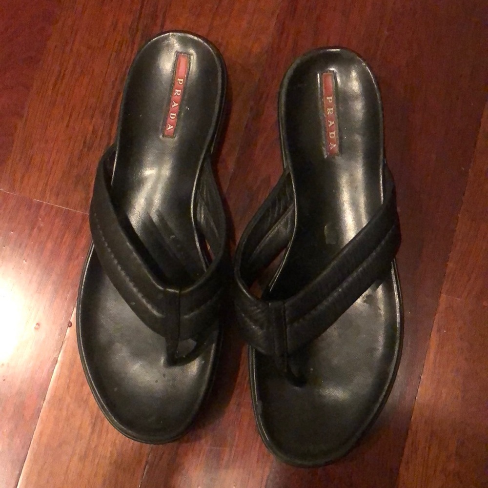 Black leather Prada flip flops.